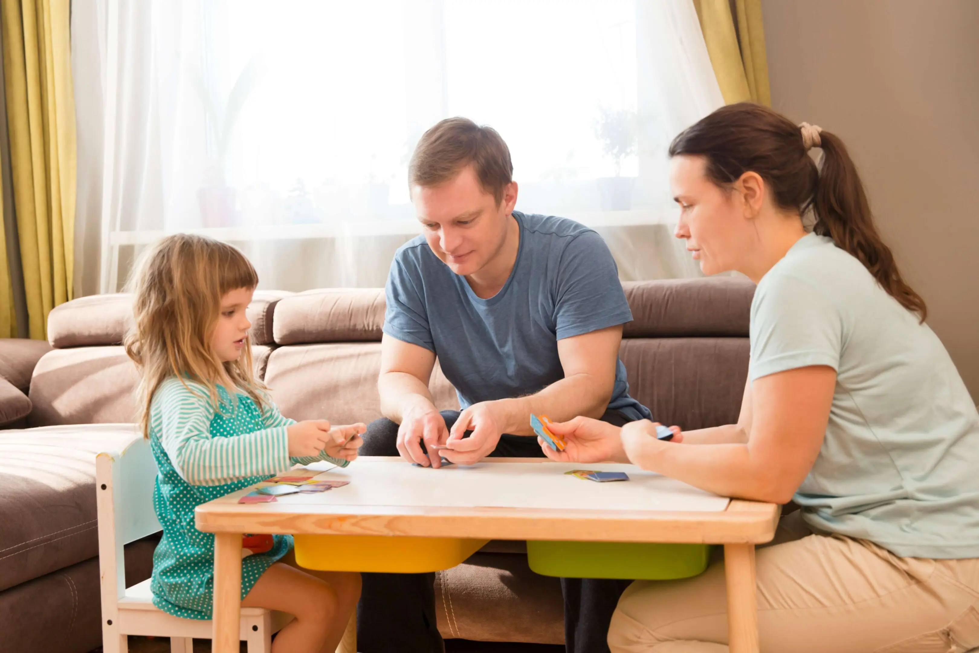 Family playing a card game together at a table.
